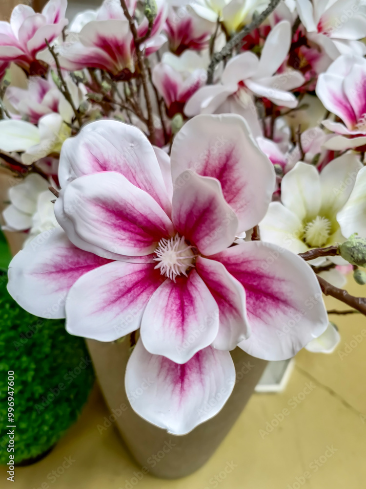 Fototapeta premium This is a closeup image of a beautifully arranged pink and white flower placed elegantly in a decorative vase