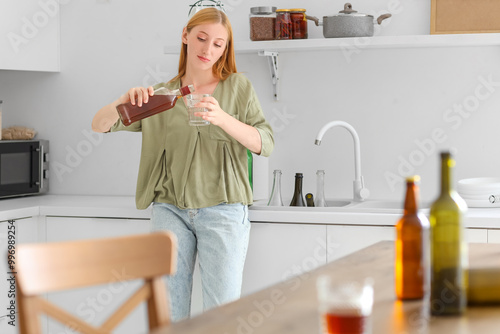 Young woman pouring alcohol...