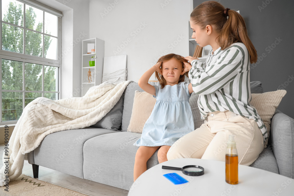 Obraz premium Mother checking her little daughter's head with pediculosis at home
