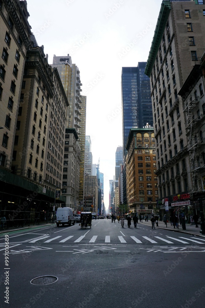 Geschäftiges Leben zwischen Wolkenkratzern und historischer Architektur auf den Straßen von New York City; Häuserflucht 57 Street, Manhattan, mit Menschen und Autos Geschäftiges Leben zwischen Wolkenkratzern und historischer Architektur auf den Straßen von New York City; Häuserflucht 57 Street, Manhattan, mit Menschen und Autos