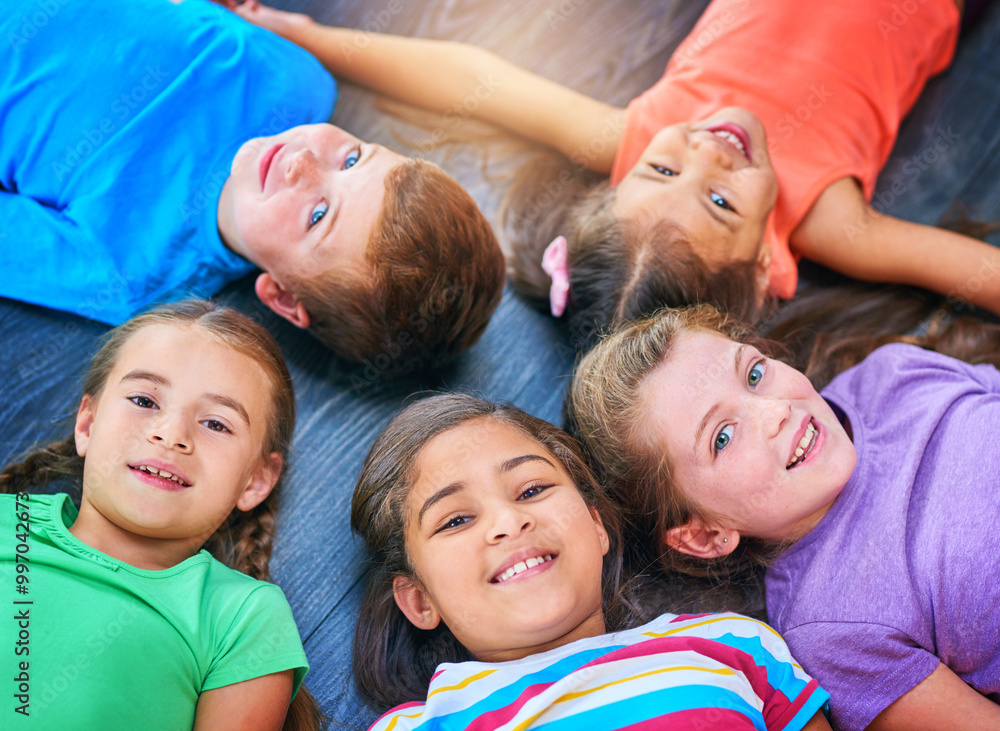 Children, circle and portrait on floor at school, above and happy for learning, bonding and development. Kids, diversity and education with huddle, friends and smile with solidarity in classroom Children, circle and portrait on floor at school, above and happy for learning, bonding and development. Kids, diversity and education with huddle, friends and smile with solidarity in classroom