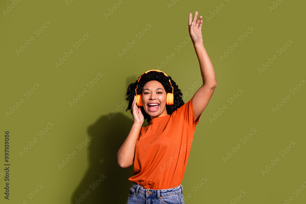 Portrait of nice young woman headphones music wear orange t-shirt isolated on khaki color background Portrait of nice young woman headphones music wear orange t-shirt isolated on khaki color background