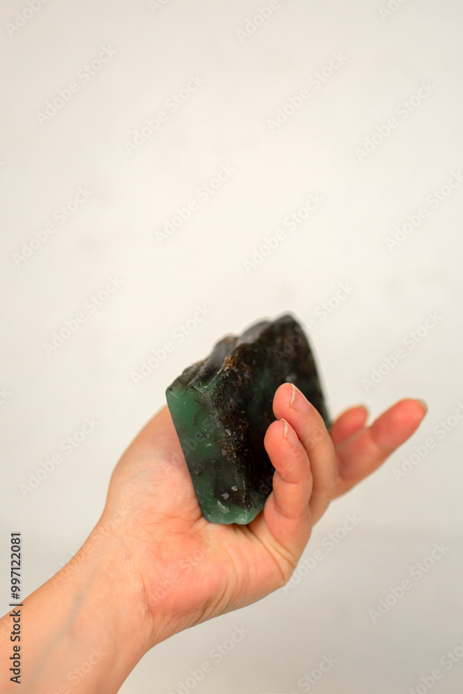A Hand Holds a Deep Green Handmade Soap Bar Against a White Background A Hand Holds a Deep Green Handmade Soap Bar Against a White Background