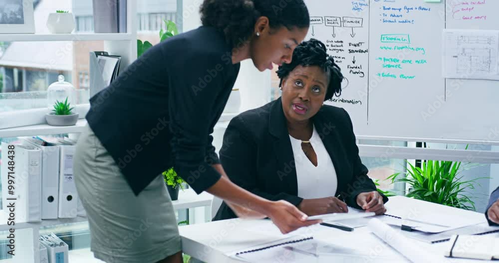 Young female manager with tablet working with colleagues in modern office. Project supervisor walking around and showing team members tasks using technology. Collaboration and teamwork