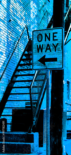 Filtered Photo of a One-Way Street Sign in front of an outdoor, open metal staircase by an Old Brick Wall of a downtown building-Urban Background, Backdrop, Border, Wallpaper, Frame in Blue