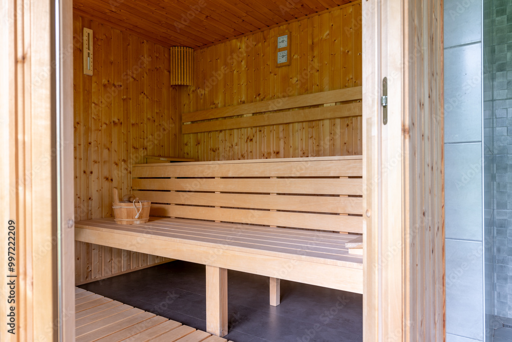 Wooden Sauna With Benches. The sauna is empty. The wooden benches provide seating for people. Wooden Sauna With Benches. The sauna is empty. The wooden benches provide seating for people.