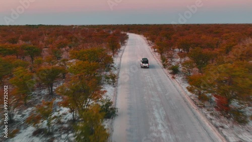 White pick up four by four carrying equipment, driving on the sand of the Namib desert .