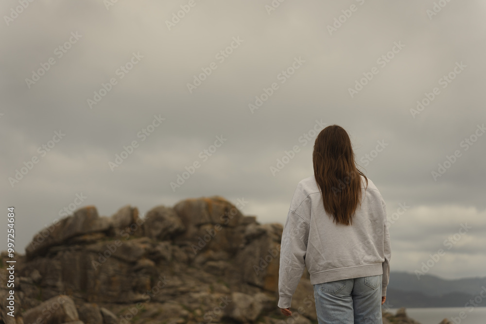 Woman facing the horizon at Castro de Baroña ruins Woman facing the horizon at Castro de Baroña ruins