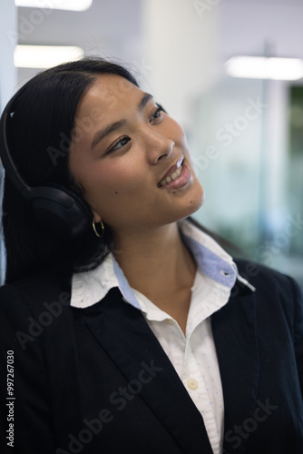 Young female entrepreneur takes a work break to relax with music on her headphones