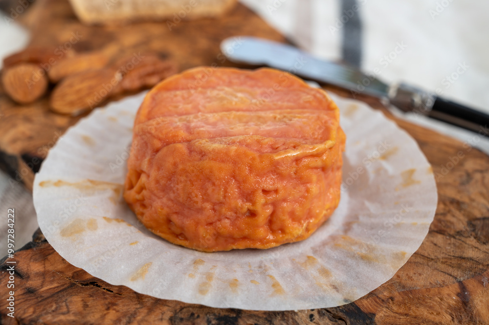 Rond des Vignes washed-rind cheese with.ivory-orange rind, strong nose with aromas, French soft cheese with orange rind Rond des Vignes washed-rind cheese with.ivory-orange rind, strong nose with aromas, French soft cheese with orange rind