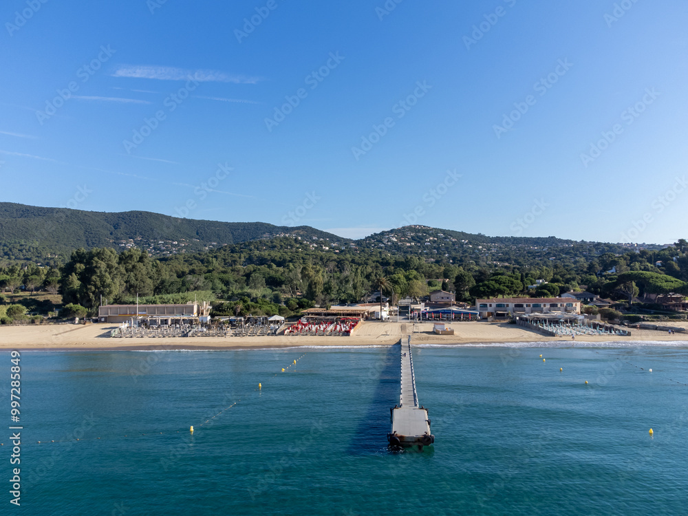 Obraz premium Aerial view on boats, crystal clear blue water of Plage du Debarquement white sandy beach near Cavalaire-sur-Mer and La Croix-Valmer, summer vacation on French Riviera, Var, France