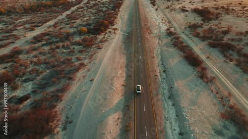 White pick up four by four carrying equipment, driving on the sand of the Namib desert .