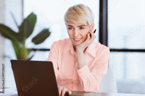 Smiling Mature Business Lady At Laptop Computer Working On A Project Sitting At Workplace In Office. Selective Focus