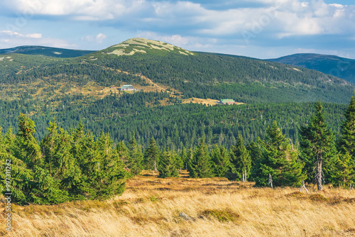 Karkonosze Mountains, Western Sudetes, mountain landscape on the hiking trail, view from the trail to the Maly Szyszak peak and mountain shelters surrounded by forest on the slopes.