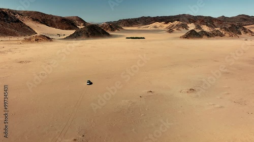An aerial view of a car driving in Sandwich Harbour, Walvis Bay, Namibia.
