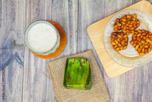 Village food menu consisting of a glass of milk, emping snacks and white sticky rice tape photo