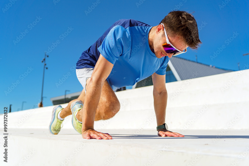 Athlete Performing Push-Up Exercises on a White Ledge in Sunny Outdoor Environment With Clear Blue Sky Athlete Performing Push-Up Exercises on a White Ledge in Sunny Outdoor Environment With Clear Blue Sky
