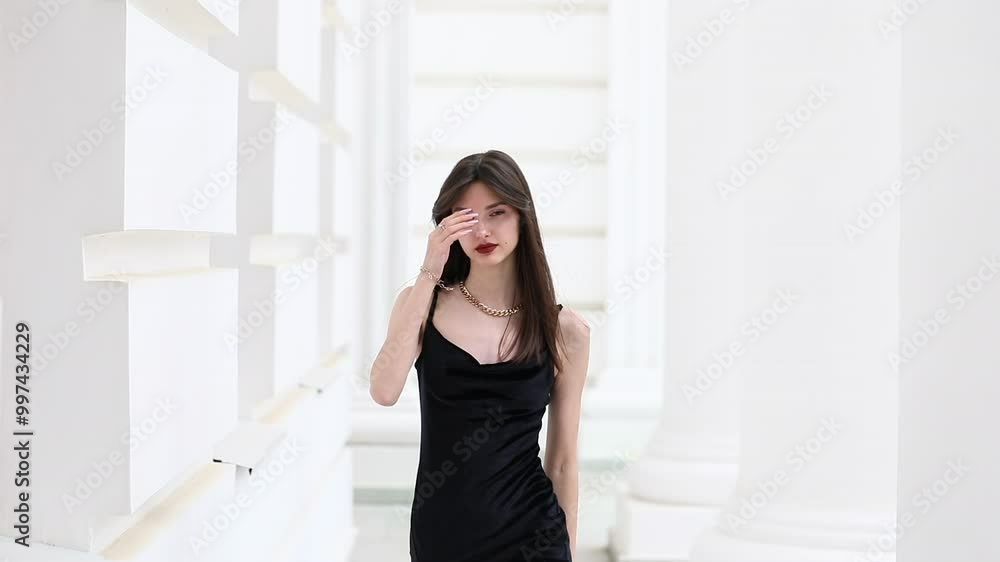 Young beautiful brunette girl posing in white columned hall
