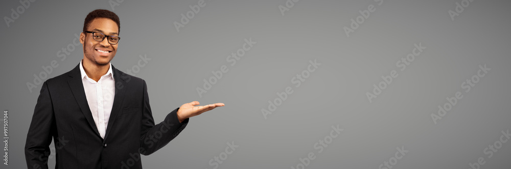 Buy This. Happy afro businessman holding invisible object on his palm, white studio wall, copyspace, panorama Buy This. Happy afro businessman holding invisible object on his palm, white studio wall, copyspace, panorama
