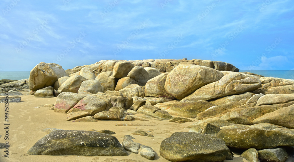 On the beach there are rocks, large boulders and sea sand and On the beach there are rocks, large boulders and sea sand and
