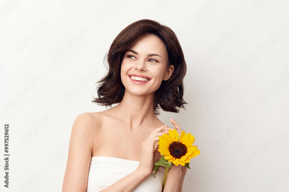 Smiling young woman posing with sunflower on white background Smiling young woman posing with sunflower on white background