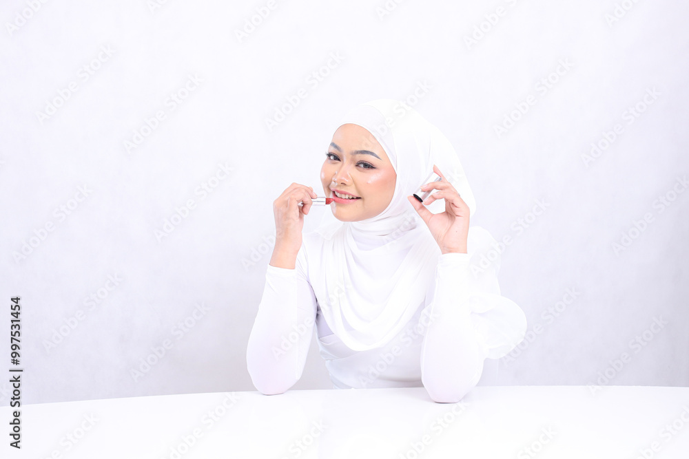 charm of lip makeup Beautiful mature woman indonesia hijab cheerful to camera hand applying lipstick to lips and lid isolated white background. cosmetic advertising concept, lip color,lipstick mock up charm of lip makeup Beautiful mature woman indonesia hijab cheerful to camera hand applying lipstick to lips and lid isolated white background. cosmetic advertising concept, lip color,lipstick mock up