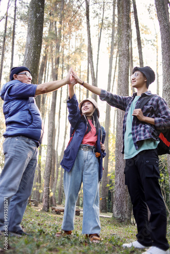 Asian Dad and Mature Children Making High Five Together at The Pine Forest