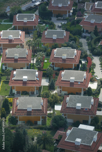 Aerial view of modern homes with striking red roofs in a nearby residential area