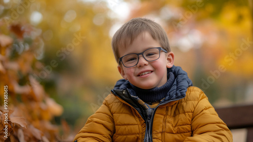 Wallpaper Mural Young boy wearing glasses smiling warmly while surrounded by autumn foliage in a park Torontodigital.ca