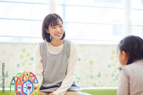 Cuadro en lienzo 託児所でおもちゃで子供と遊ぶ保育士の女性