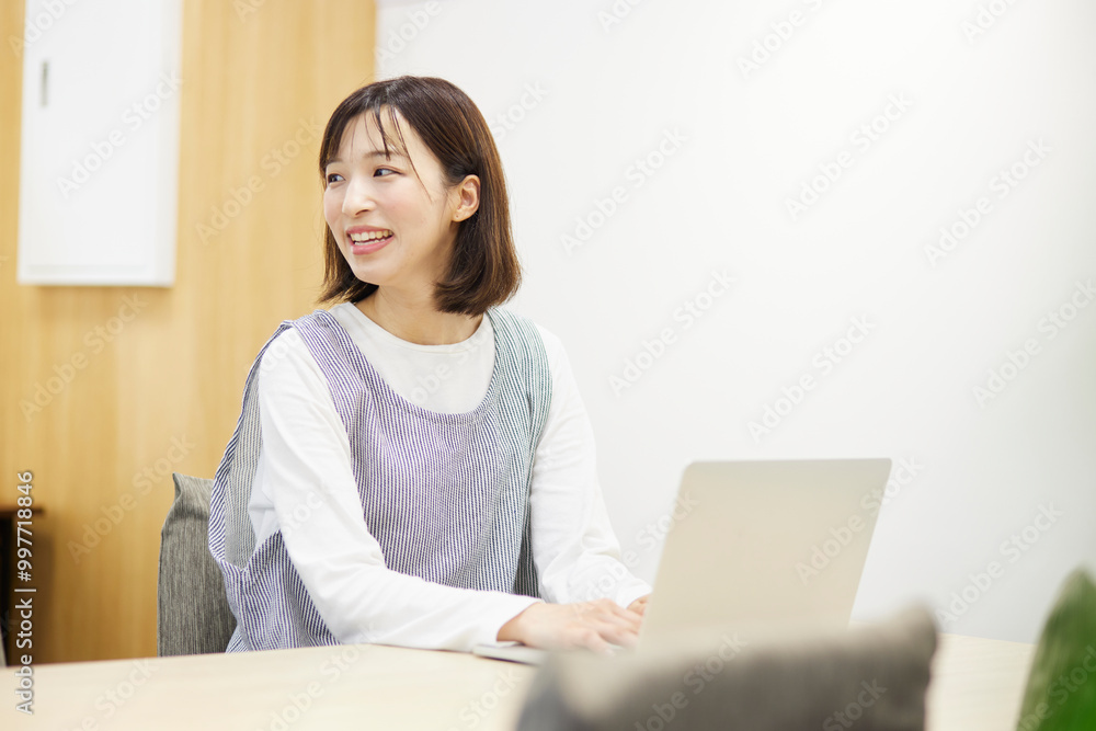 保育園でノートパソコンを使用して仕事をする保育士の女性 保育園でノートパソコンを使用して仕事をする保育士の女性
