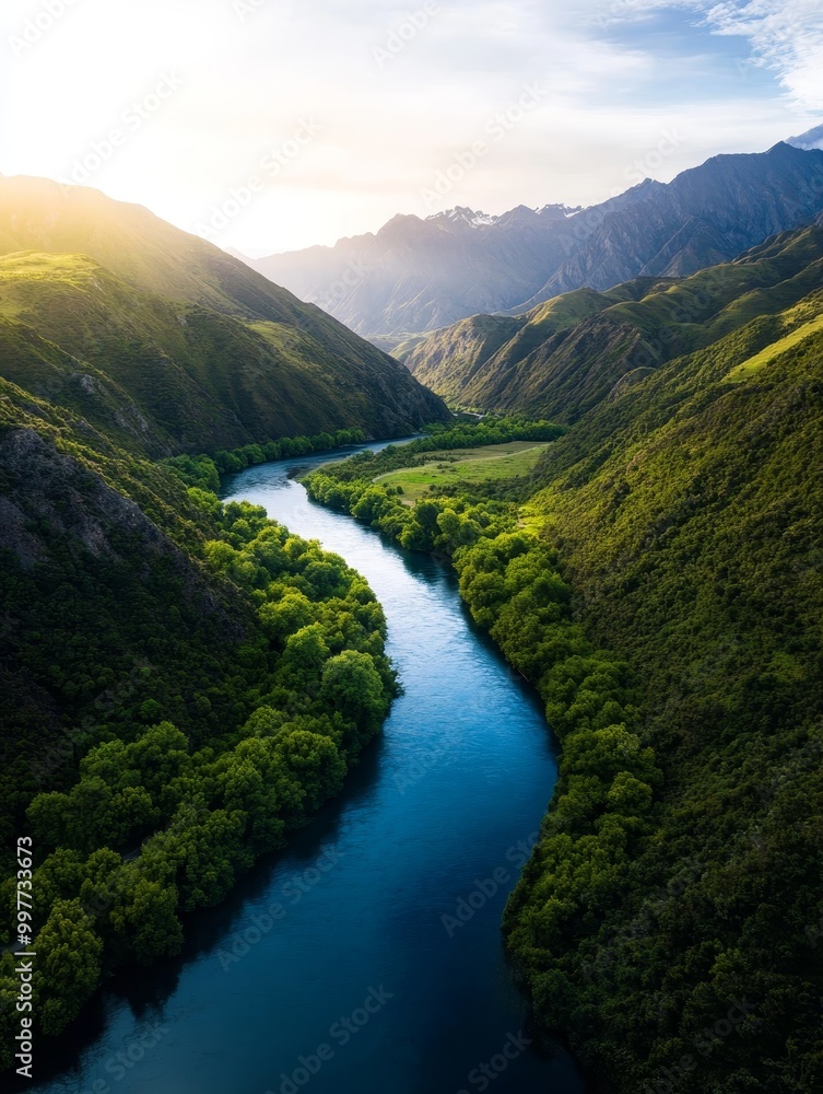 A breathtaking aerial view of the Kawarau River, a stunning turquoise ribbon winding through lush green mountains under a clear blue sky. This scenic landscape showcases the beauty of nature and the t A breathtaking aerial view of the Kawarau River, a stunning turquoise ribbon winding through lush green mountains under a clear blue sky. This scenic landscape showcases the beauty of nature and the t