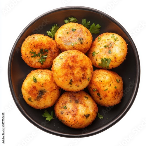 Crispy Fried Potato Balls with Green Garnish on a Black Plate photo