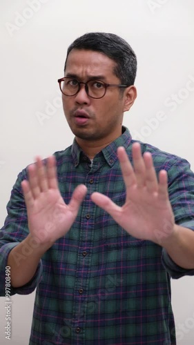 A man showing shocked expression and doing stop hand gesture photo