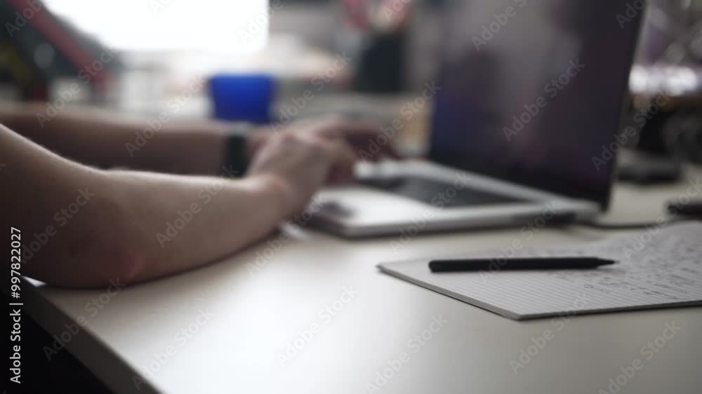 Man Writing Ideas While Working on Laptop Man Writing Ideas While Working on Laptop