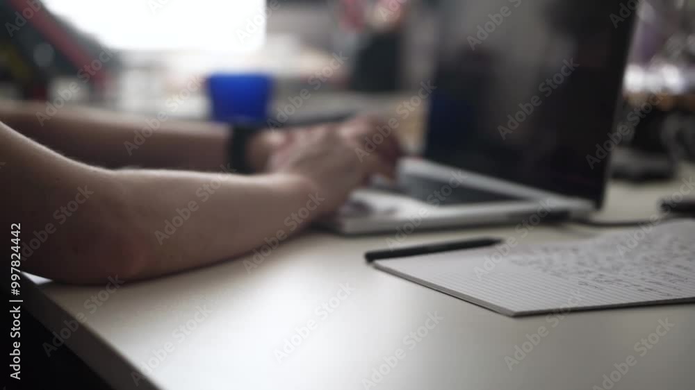 Man Writing Ideas While Working on Laptop Man Writing Ideas While Working on Laptop