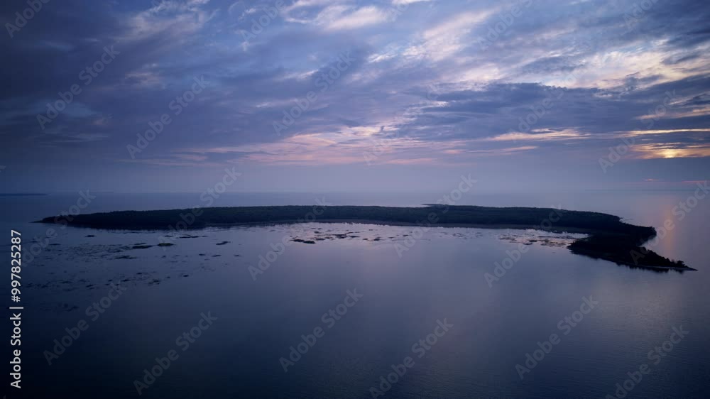 Drone shot flying over lake michigan towards little summer island on color evening at dusk Drone shot flying over lake michigan towards little summer island on color evening at dusk