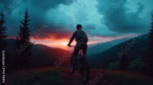 Blurred Silhouette of a Cyclist Riding Along a Mountain Trail at Dawn