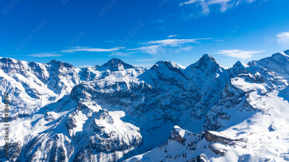 Obraz premium The banner mountain view of alpine as snow-capped mount peaks scene in Winter mountains background