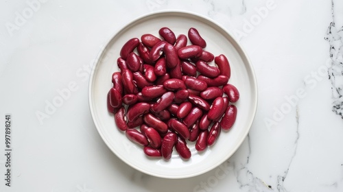 A white plate with a bunch of red beans on it