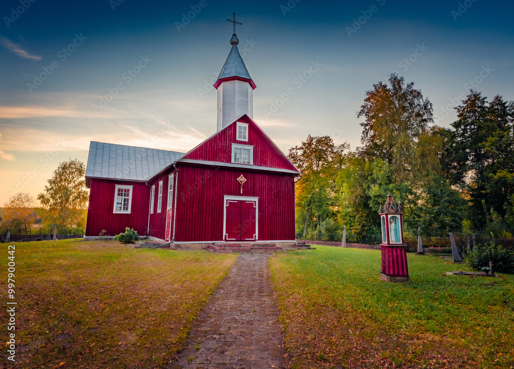 Attractive evening view of red wooden St. Onos Catholic church, Stunning autumn sunset on Duokiskis village, Rokiskis District Municipality, Latvia, Europe. Traveling concept background. Attractive evening view of red wooden St. Onos Catholic church, Stunning autumn sunset on Duokiskis village, Rokiskis District Municipality, Latvia, Europe. Traveling concept background.