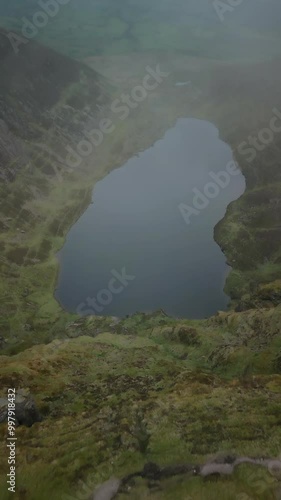 Flying over hiker in Coumshingaun Mountain in Ireland photo