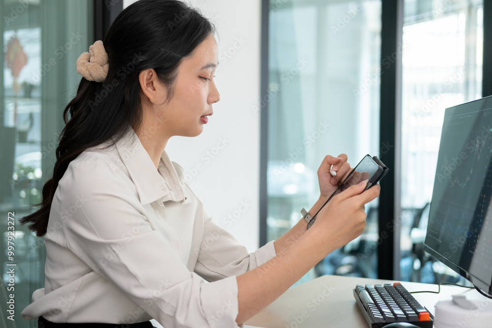 Woman examines stock graphs in tablet and computer Woman examines stock graphs in tablet and computer