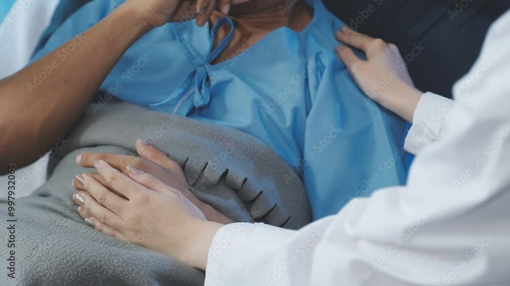 Women Asian doctors hold the patient hand and encourage and provide medical advice While checking the patient health in bed. Concept of Care and compassion, antenatal care, Threatened abortion Women Asian doctors hold the patient hand and encourage and provide medical advice While checking the patient health in bed. Concept of Care and compassion, antenatal care, Threatened abortion