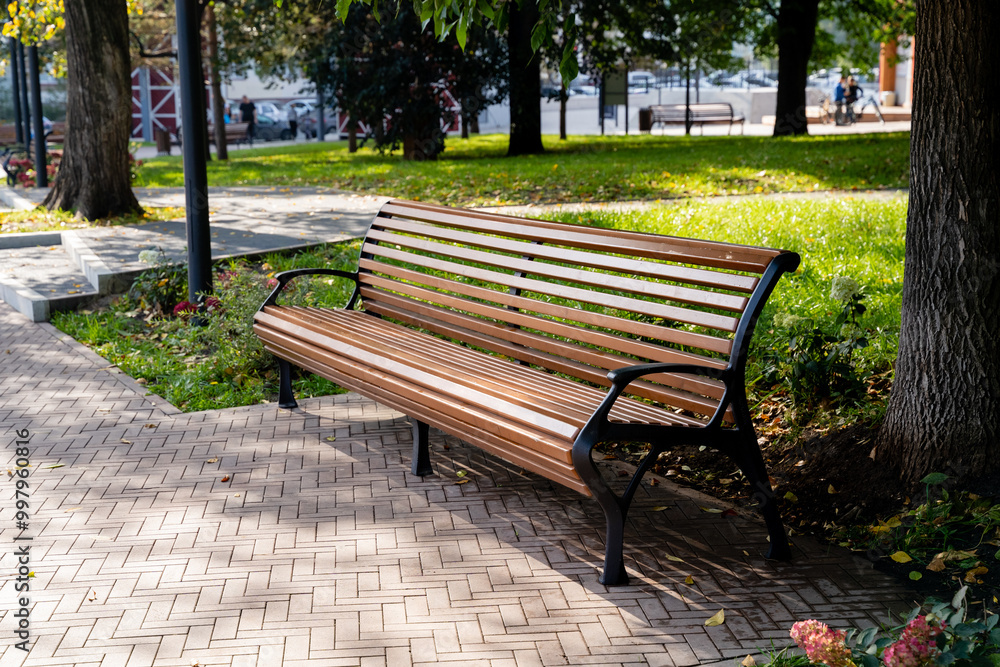 A sturdy wooden bench is elegantly positioned on a wellmaintained brick sidewalk in a lovely park, providing a perfect spot for relaxation and enjoyment of the beautiful surroundings A sturdy wooden bench is elegantly positioned on a wellmaintained brick sidewalk in a lovely park, providing a perfect spot for relaxation and enjoyment of the beautiful surroundings