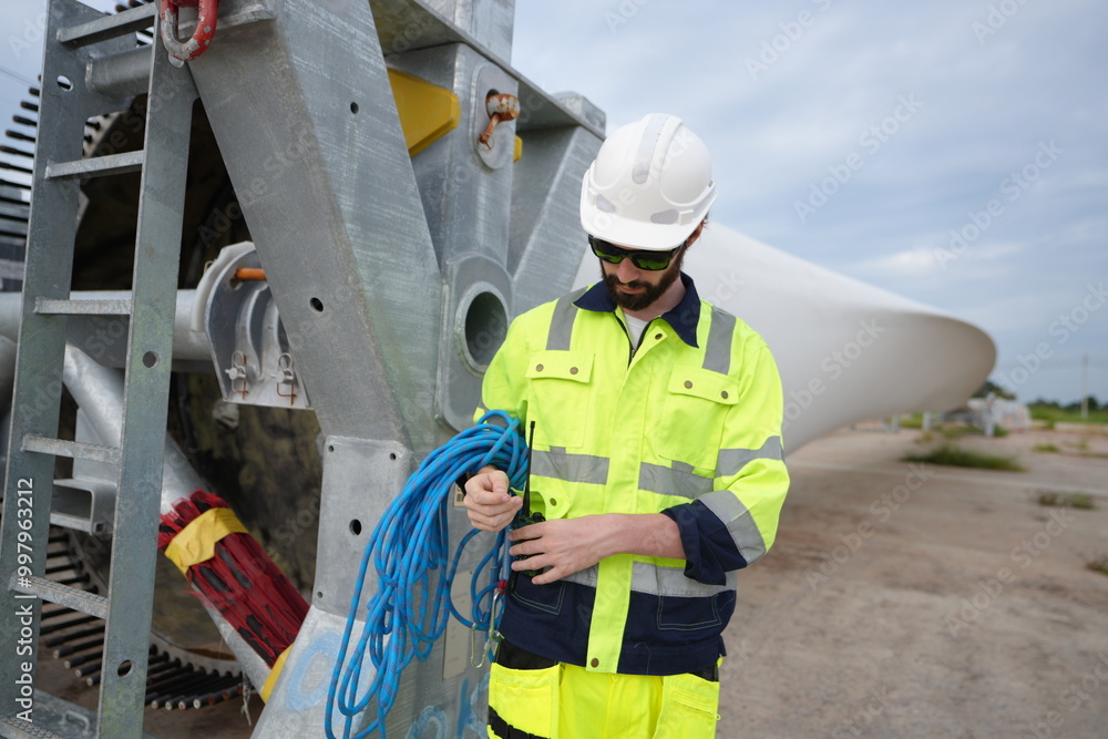 Windturbine inspector wearing Personal protective equipment working at wind turbines farm Windturbine inspector wearing Personal protective equipment working at wind turbines farm