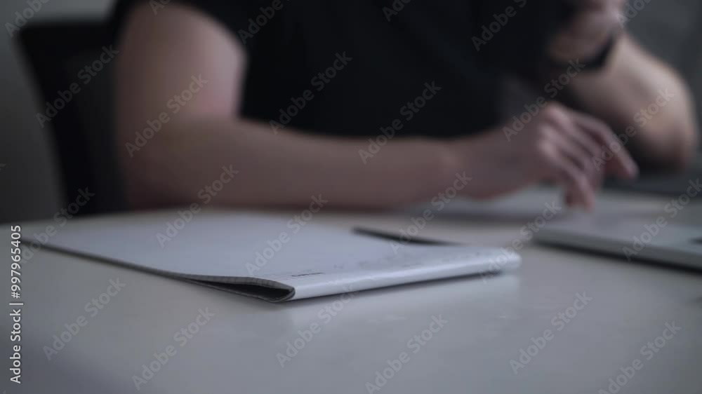 Man Working on Laptop and Taking Notes in Notebook Man Working on Laptop and Taking Notes in Notebook
