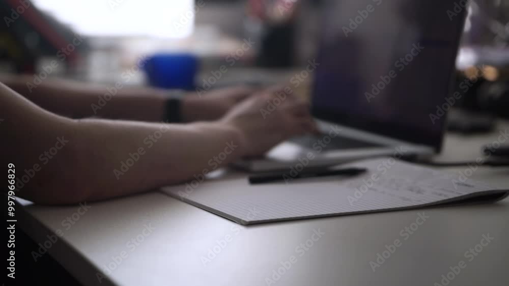 Man Working on Laptop and Taking Notes in Notebook Man Working on Laptop and Taking Notes in Notebook
