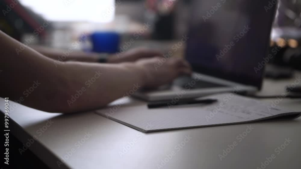 Man Working on Laptop and Taking Notes in Notebook Man Working on Laptop and Taking Notes in Notebook