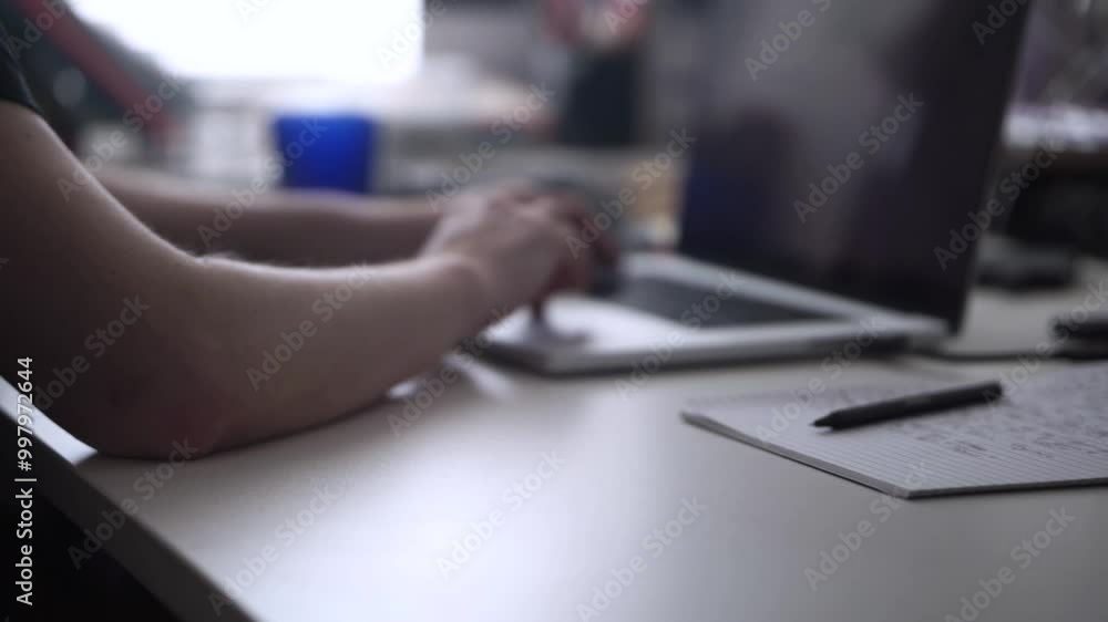 Man Working on Laptop and Taking Notes in Notebook Man Working on Laptop and Taking Notes in Notebook